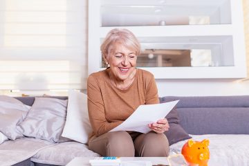Senior woman smilling and happy about her finances. Old lady receives a letter.Senior lady receiving good news from a paper mail.